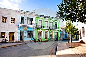 Bici or bike taxi`s waiting in front of colorful colonial house in Camaguey.