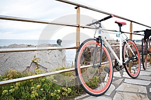 bicicleta aparcada sobre una barandilla con unas hermosas vistas al mar photo