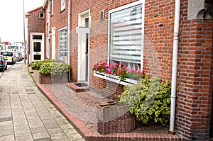 Bick House with big Windows along a Sidewalk