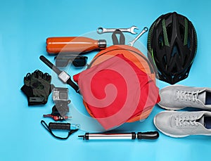 Bicycle accessories and equipment on light blue background, flat lay