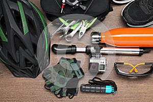 Bicycle accessories and equipment on wooden background, flat lay