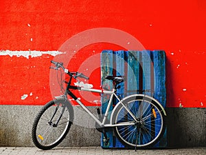 Bicycle against red wall and blue wooden palette
