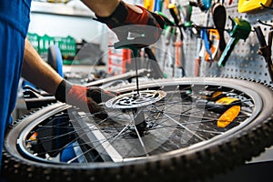 Bicycle assembly in workshop, man installs brake