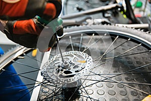 Bicycle assembly in workshop, man installs brake