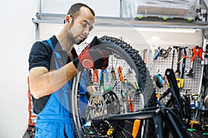 Bicycle assembly in workshop, man installs wheel