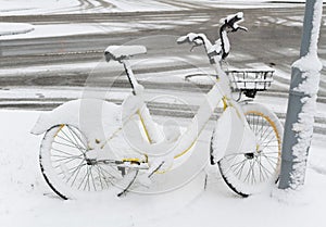 bicycle bike covered with snow parked by the city road