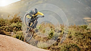 Bicycle, biker and jump in air for competition, mountain biking and extreme sport with helmet, outdoor and in nature