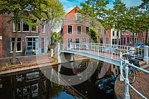 Bicycle on bridge and canal with cars parked along in Delft street