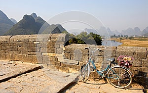 A bicycle on a bridge crossing the Yulong River near Yangshuo, Guilin in Guangxi Province, China