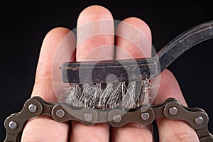 Bicycle chain and metal brush for cleaning dirt. Care of the bicycle& x27;s drive system