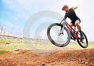 Bicycle, countryside and woman on a bike with speed for sports race on a dirt road. Fitness, exercise and athlete doing