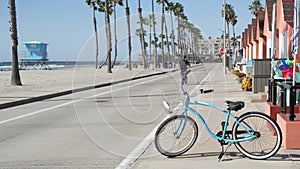 Bicycle cruiser bike by ocean beach, California coast USA. Summer cycle, lifeguard hut and palm tree