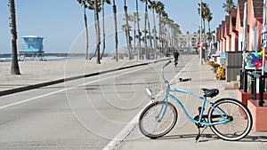 Bicycle cruiser bike by ocean beach, California coast USA. Summer cycle, lifeguard hut and palm tree