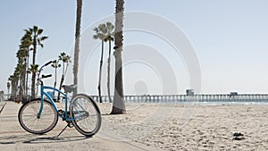 Bicycle cruiser bike by ocean beach, California coast USA. Summer cycle, lifeguard hut and palm tree photo