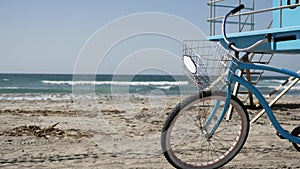 Bicycle cruiser bike by ocean beach California coast USA. Summer sea shore. Cycle by lifeguard tower