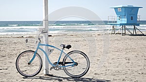 Bicycle cruiser bike by ocean beach California coast USA. Summer sea shore. Cycle by lifeguard tower