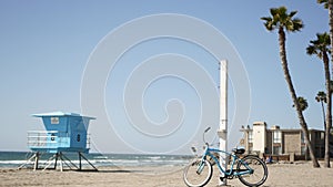 Bicycle cruiser bike by ocean beach California coast USA. Summer sea shore. Cycle by lifeguard tower