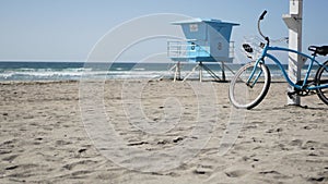 Bicycle cruiser bike by ocean beach California coast USA. Summer sea shore. Cycle by lifeguard tower