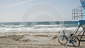 Bicycle cruiser bike by ocean beach California coast USA. Summer sea shore. Cycle by lifeguard tower