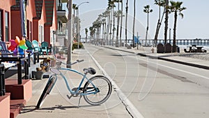 Bicycle cruiser bike by ocean beach, California coast USA. Summertime cycle, cottages and palm tree.