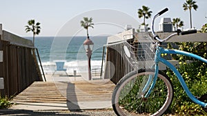 Bicycle cruiser bike by ocean beach, California coast USA. Summertime cycle, stairs and palm trees.