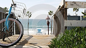 Bicycle cruiser bike by ocean beach, California coast USA. Summertime cycle, stairs and palm trees.