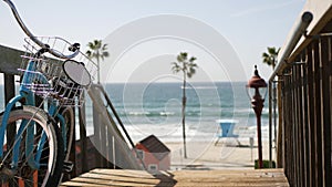 Bicycle cruiser bike by ocean beach, California coast USA. Summertime cycle, stairs and palm trees.