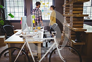 Bicycle by desk while coworkers discussing in background