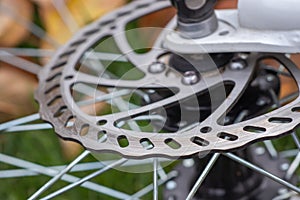 Bicycle disk brakes close up, grey metal disc attached to bike wheel, effective popular mountain bicycle brakes