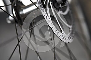 Bicycle disk brakes close up, metal disc attached to bike wheel, effective mountain bicycle brakes
