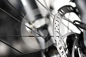 Bicycle disk brakes close up, metal disc attached to bike wheel, effective mountain bicycle brakes