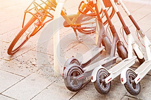 Bicycle and electric scooters parked on city street. Self-service street transport rental service. Rent urban vehicle with