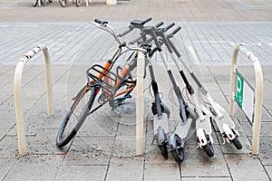 Bicycle and electric scooters parked on city street. Self-service street transport rental service. Rent urban vehicle