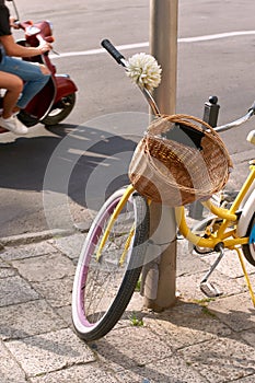 Bicycle with a front bike wicker basket parked on a sunny street while
