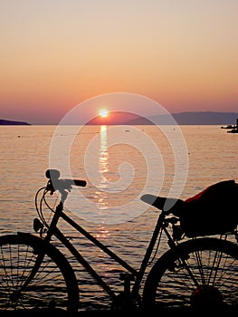 Bicycle in front of sun set and lake
