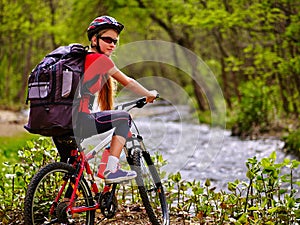 Bicycle girl with big rucksack cycling fording throught water .