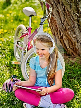 Bicycle girl wearing headset watching at tablet pc.