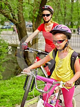 Bicycle girls with rucksack cycling on bike lane.