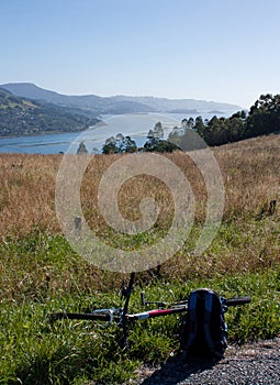 A bicycle on the ground and a view at the Otago Peninsula near Dunedin in New Zealand on a sunny day