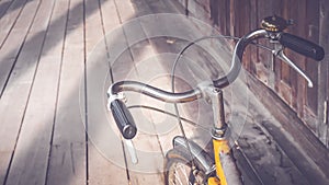 Bicycle handle bar close up. Vintage filter. wooden floor background