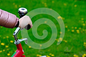 Bicycle handlebar in the hands of a rebec on a blurred background of grass with space for text