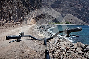 Bicycle handlebars overlooking the cliff and the beach