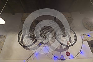 Bicycle hanging on the wall with Christmas lights and chandeliers