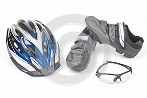 Bicycle helmet, glasses and cycling shoes on a white background