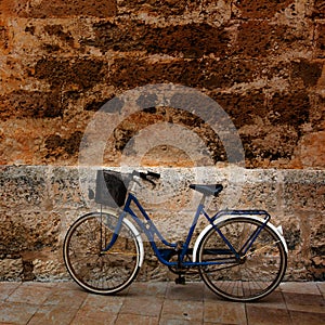 Bicycle in historical Ciutadella stone wall at Balearics