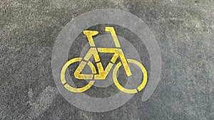 Bicycle icon in the middle. Bicycle parking area with bicycle sign on top of the asphalt in the middle of the park