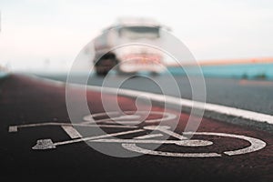 Bicycle lane sign with blurred truck in background