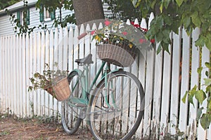 Bicycle Leaning on a White Picket Fence