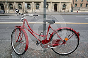 A BICYCLE LOCKED TO A LAMP POST