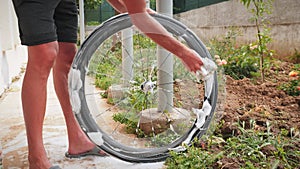 Bicycle maintenance. Man washing his road bike after dirt ride. Bike mechanic cleaning bicycle wheel with white soap foam and wash